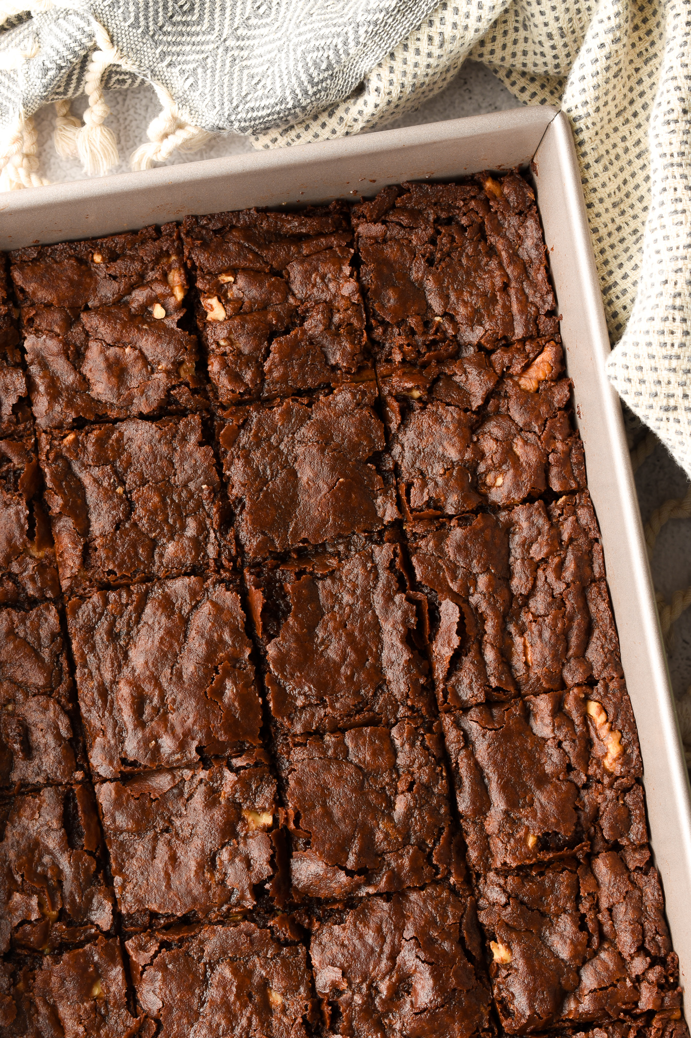 Perfect fudgy vegan brownies with cracked tops in a pan